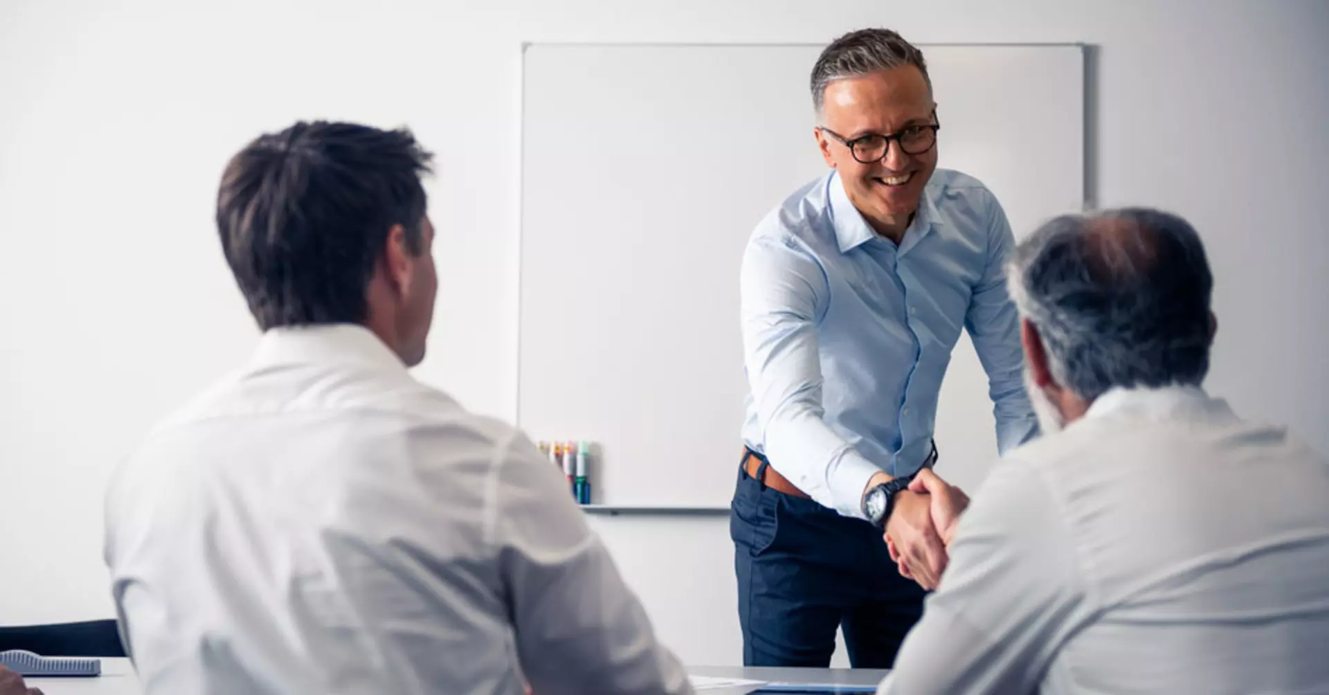 Salesperson and customer shaking hands in a meeting