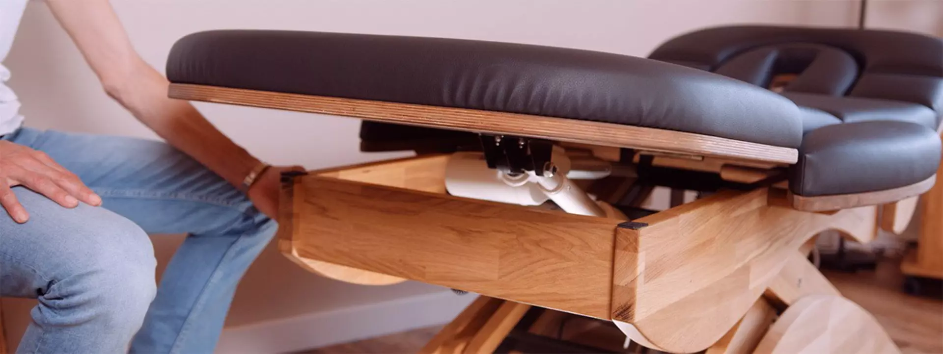 White LINAK actuator raising headrest on black massage couch.