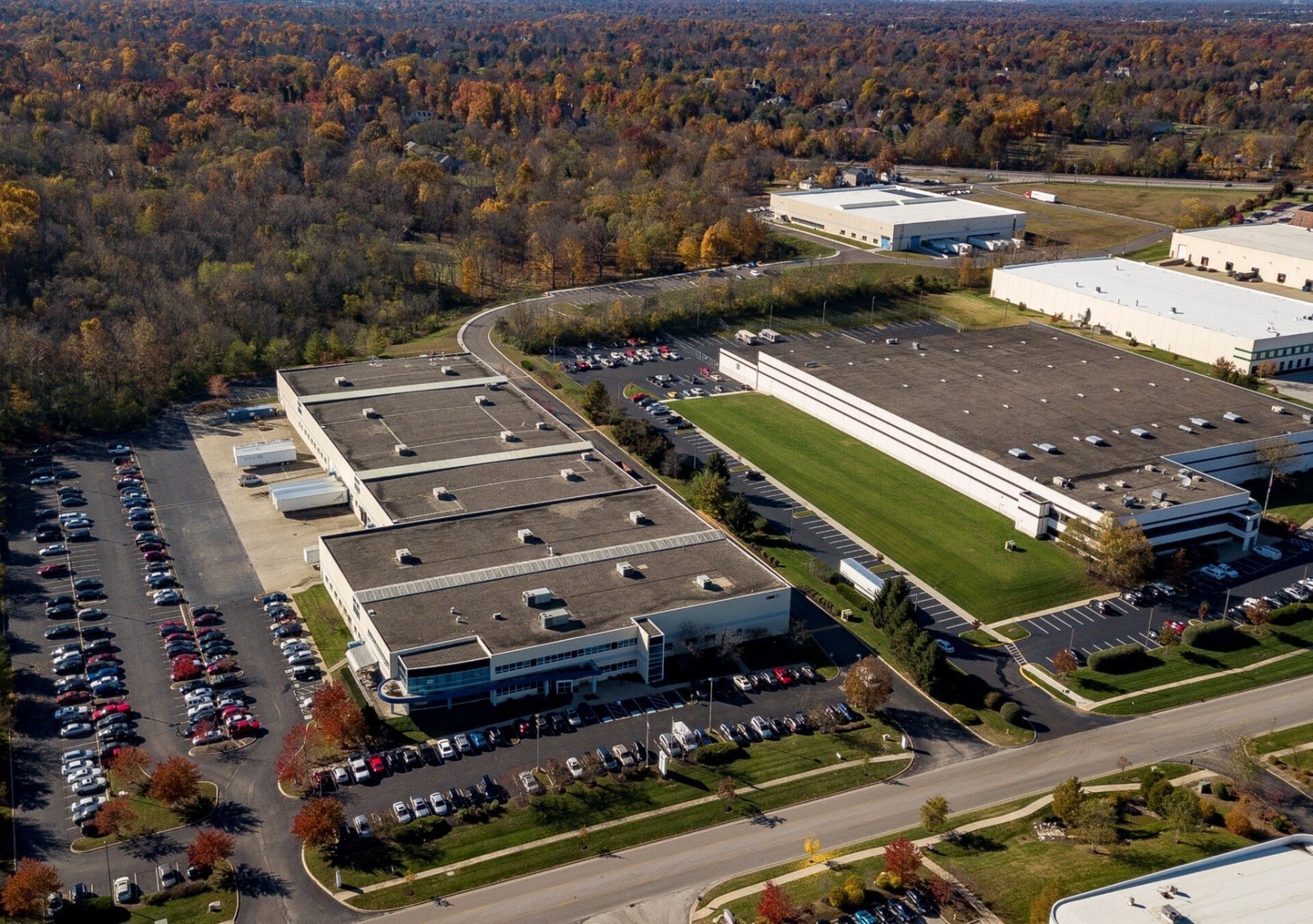 Aerial view of LINAK US - a manufacturing facility with several buildings, parking areas, and surrounding green spaces.
