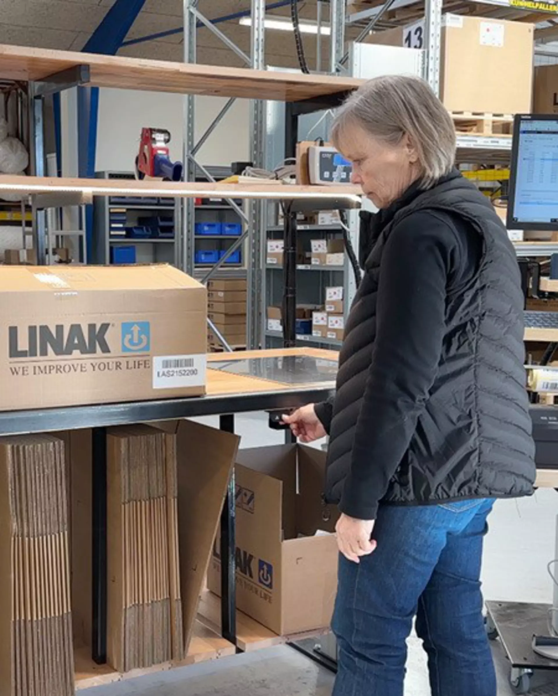 Pia adjusts the height of the packing workstation.