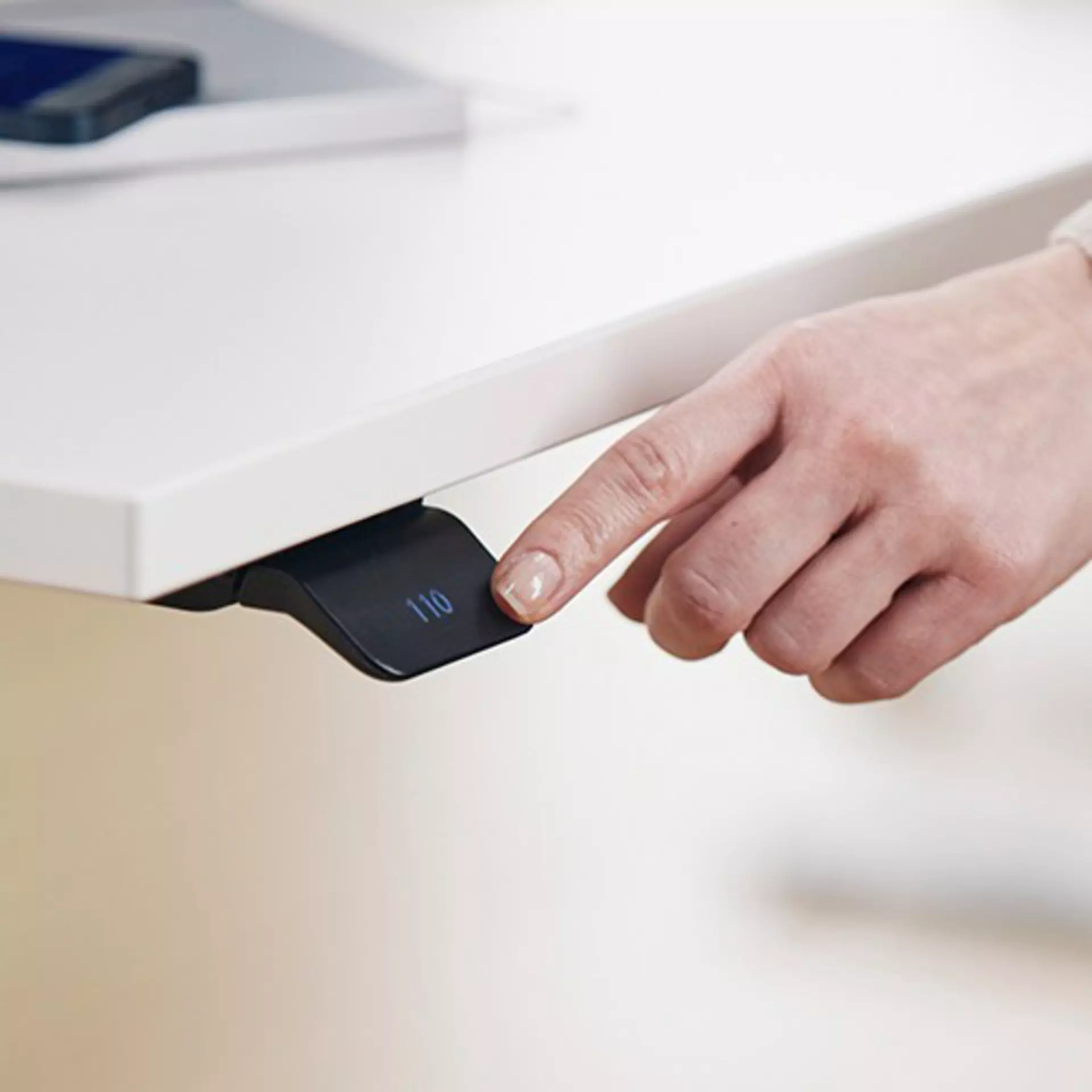LINAK DPI1C desk panel with display intuitively operated via a gentle tilt of the paddle - elegantly mounted on the tabletop of a sit-stand desk.