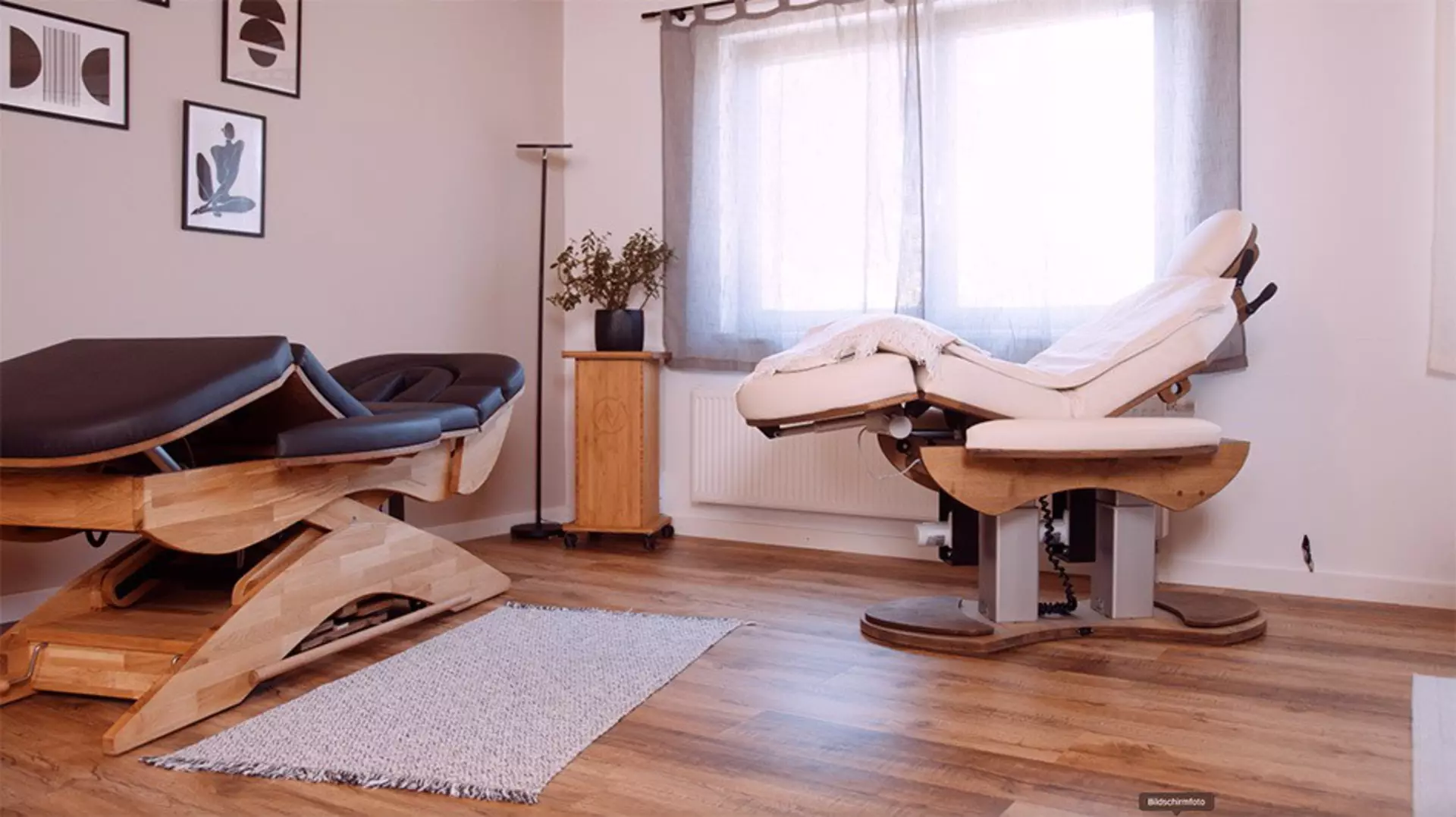 Two couches, a black and white couch, with wooden frames placed in treatment room.