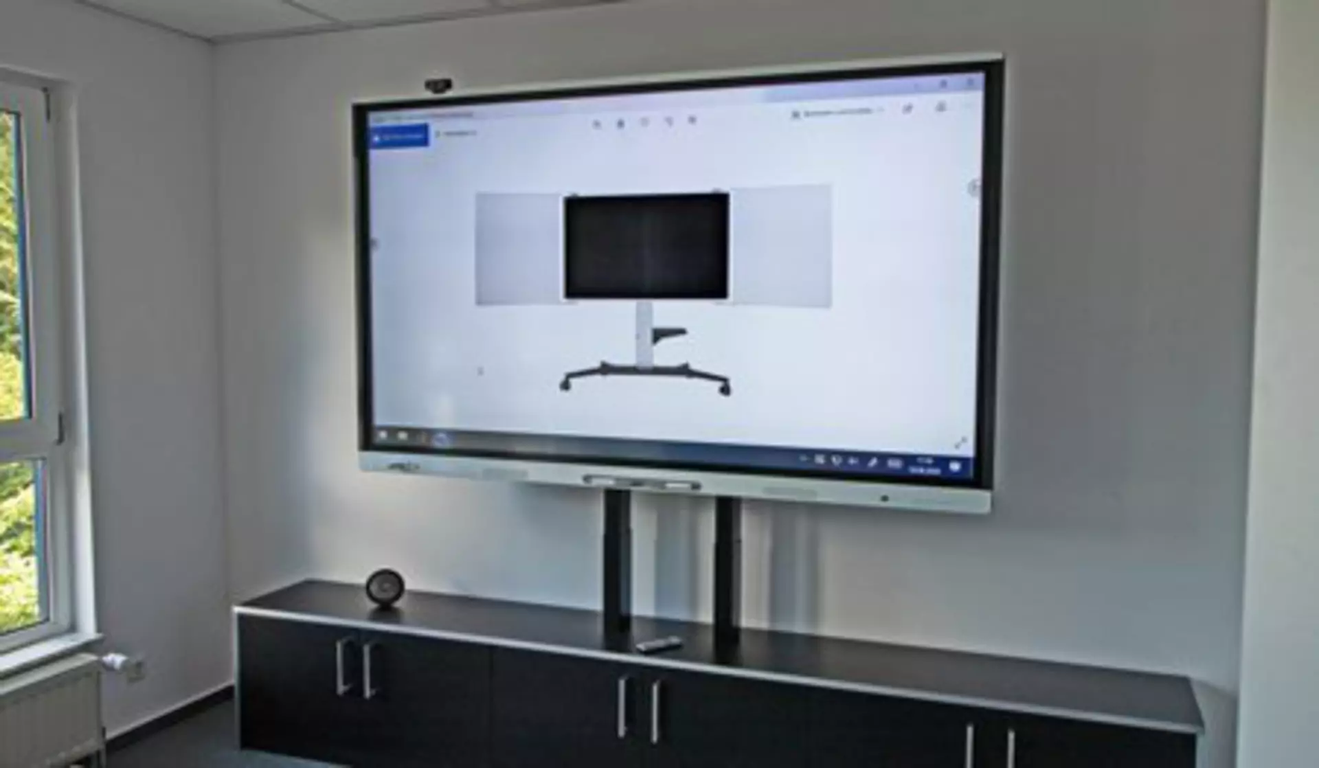 Large, height-adjustable display in meeting or conference room. Adjusted via LINAK electric actuators.
