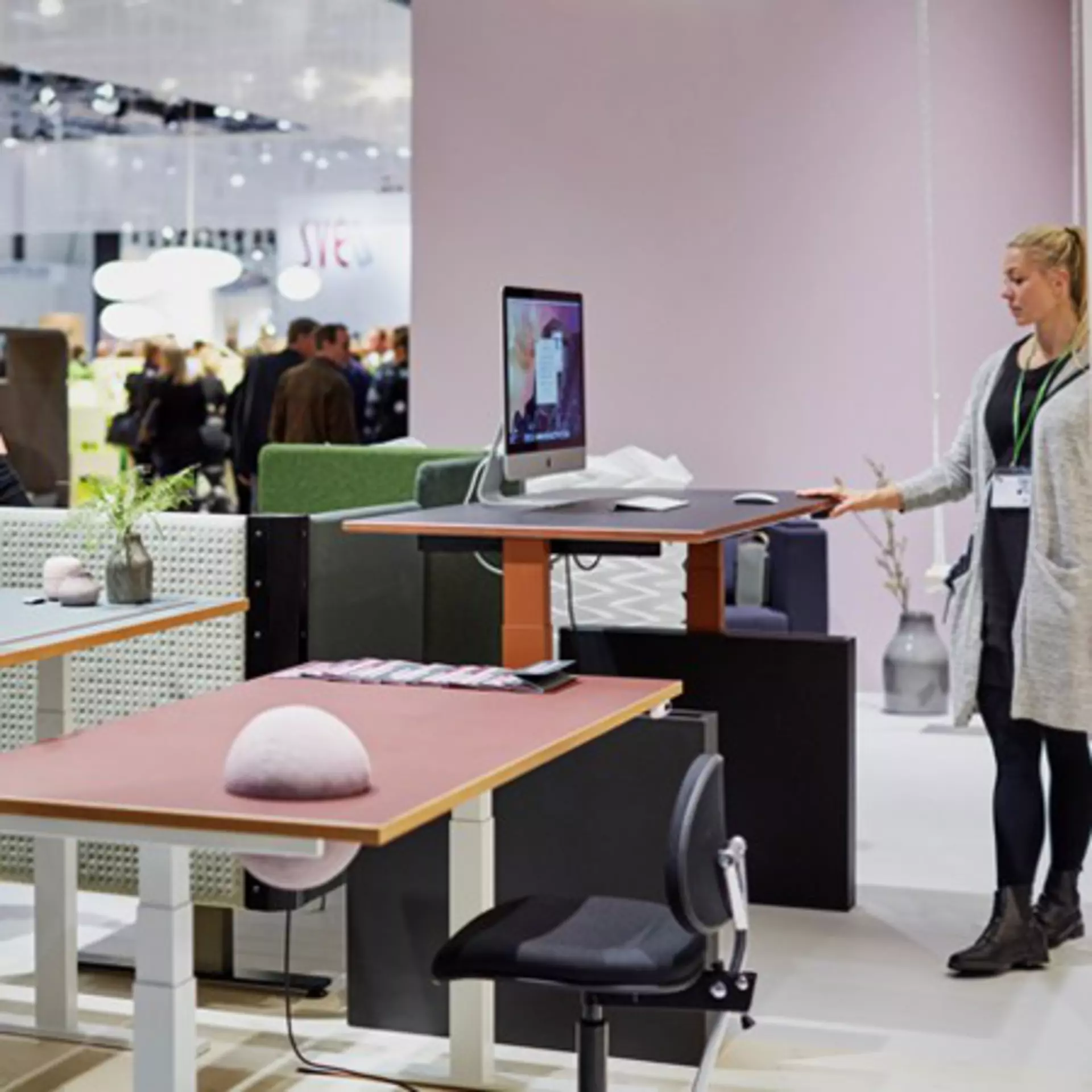 Modern office landscape with ergonomic and colourful height-adjustable tables - powered by LINAK lifting columns.