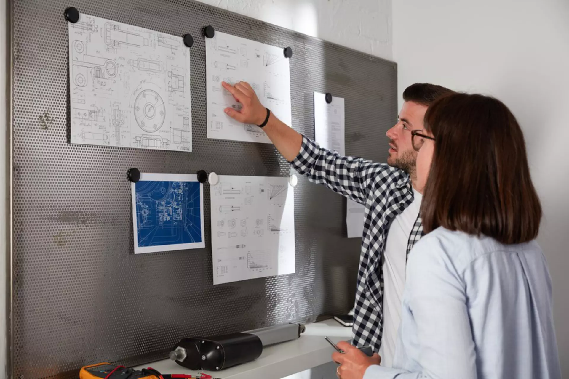 Two people are analyzing linear actuators for their application requirements