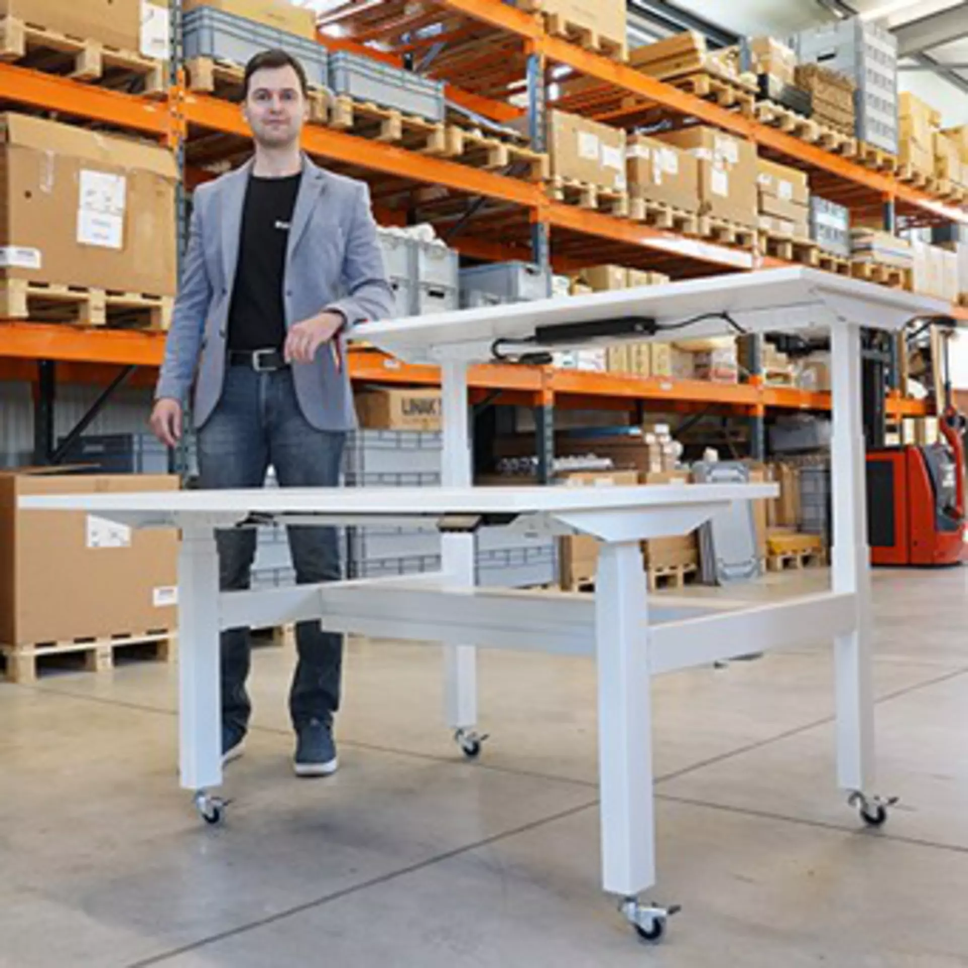 Tsvetomir Pantaleev, founder of BULDESK, next to a LINAK powered electric height-adjustable bench desk system on casters