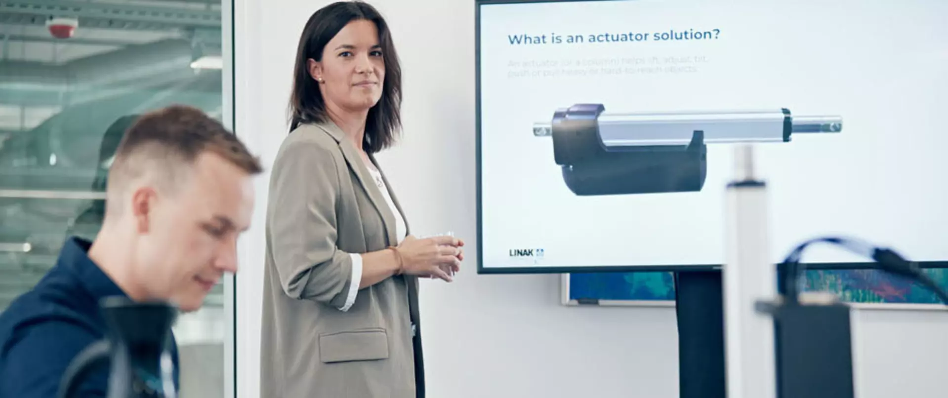 Two persons explaining what a linear actuator is